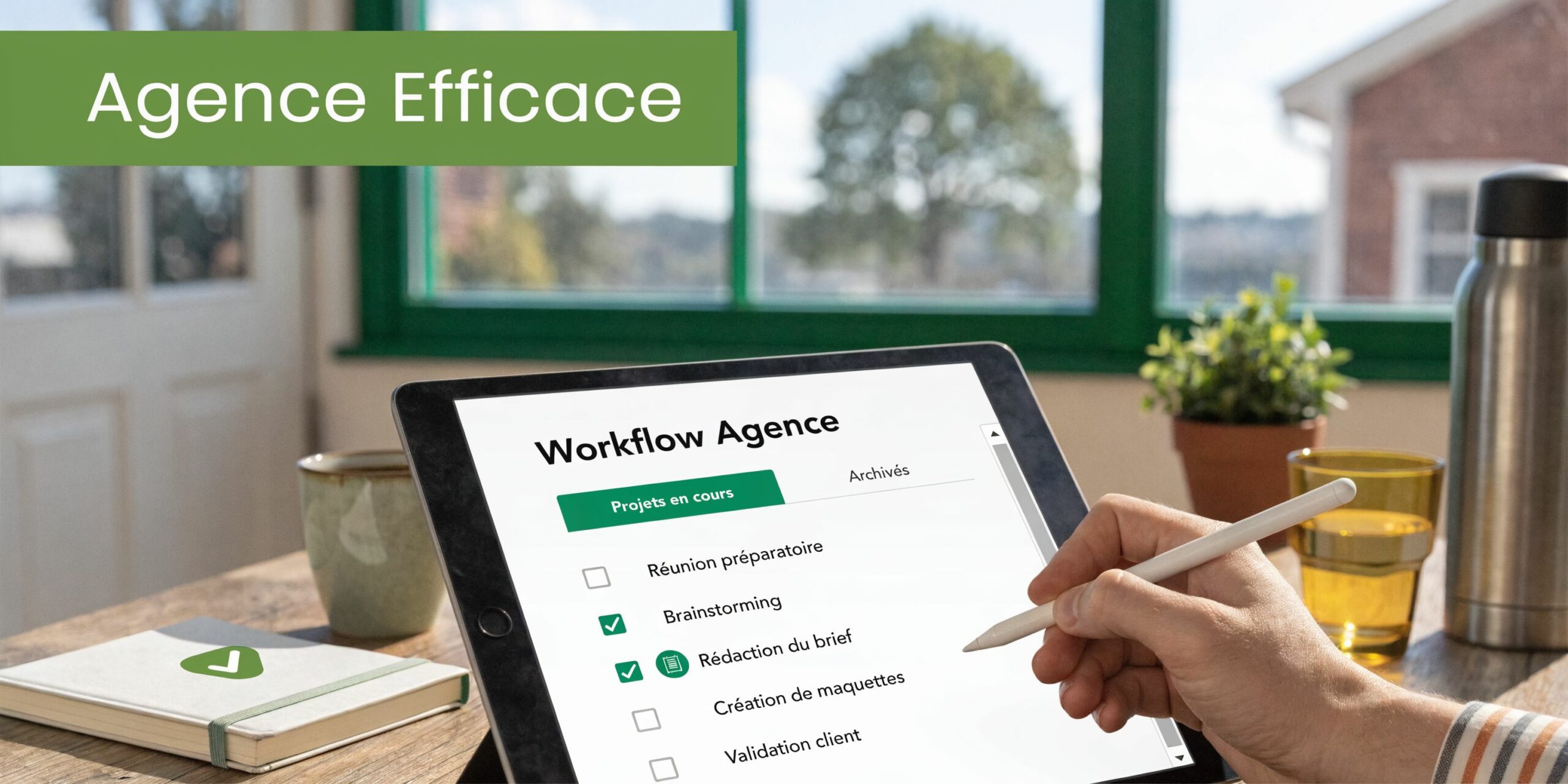 Une tablette affichant un flux de travail d'agence tenu par une main utilisant un stylet numérique.